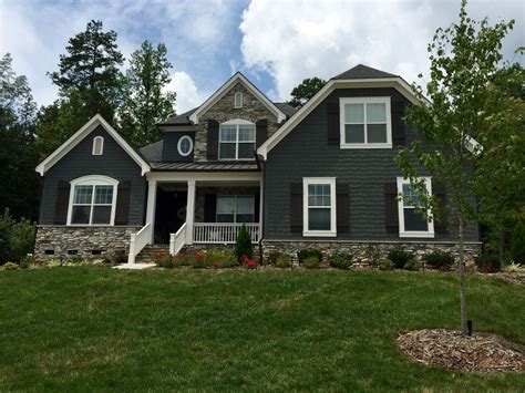 dark green house with gray metal roof|dark grey brick house.